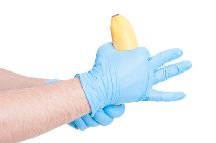 Doctor hands making obscene gesture with a banana
